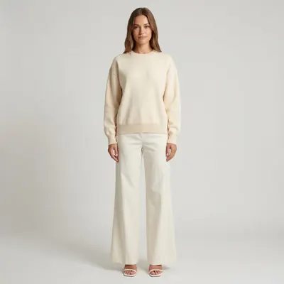 Sweter i spodnie na modelce, na jasnym studyjnym tle